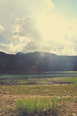 Idyllic lake landscape in the mountains on a sunny day; nature. Image filtered in faded, nostalgic, retro, Instagram style with lens flare. Black lake, Durmitor, Montenegro. - 119206202