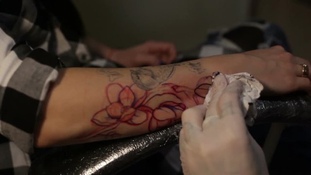 Painful procedure of getting tattoo from professional tattoo artist.