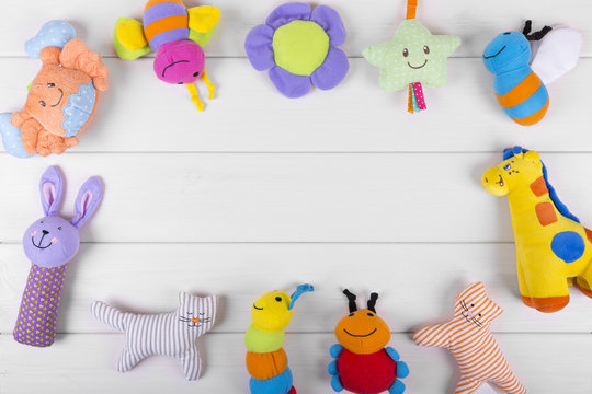 Colorful Soft Baby Toys On Wooden Background With Copy Space