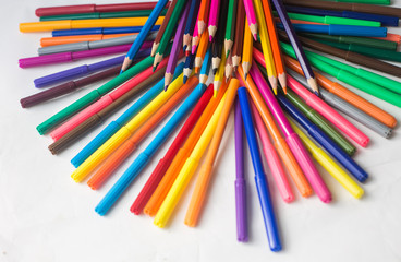 colored pencils and felt-tip pens on a white background