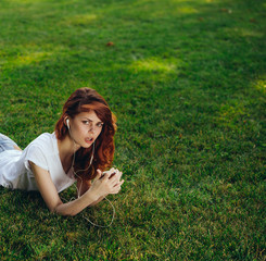 woman in headphones with the phone in the park