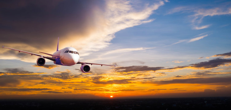 Airplane with background of cloudy sky at sunset or sunrise, exp