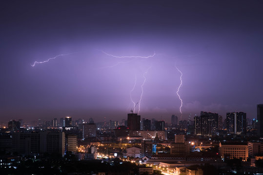 Lightning storm over city in purple light