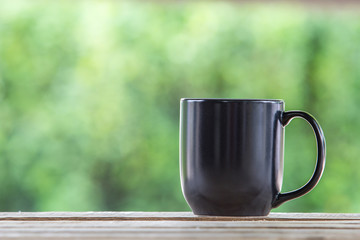 coffee mug wooden tabletop against grunge green blur background