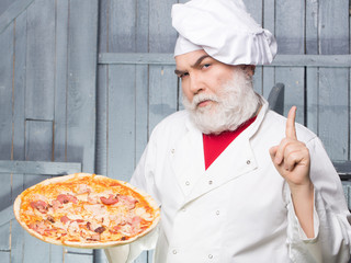 Bearded cook with pizza