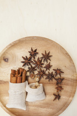 Dry herbs in canvas bag on round wooden tray with space on wood background