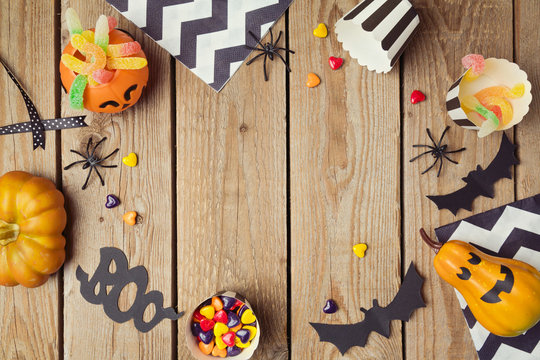 Halloween holiday background with pumpkin and candy. View from above