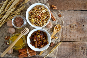 Walnuts, granola, milk and honey on wooden background