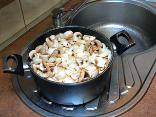 Sliced mushrooms and onions in the kettle        