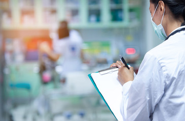 Doctor writing a medical prescription in hospital