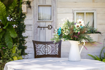 Fototapeta na wymiar Cute flower in white vase on wooden table vintage style.
