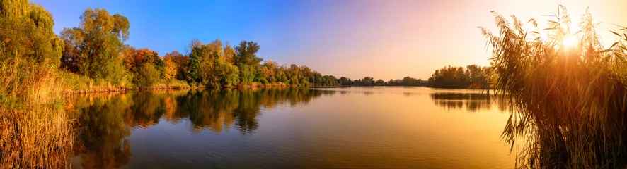 Sonnenuntergang an einem See, ein Panorama in Gold und Blau © Smileus