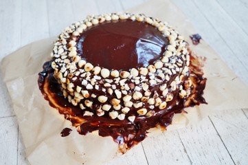 Icing a vegan chocolate and hazelnut cake in the kitchen