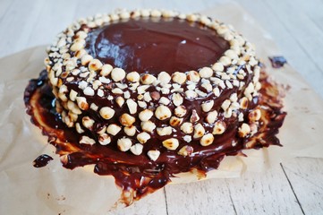 Icing a chocolate and hazelnut cake in the kitchen