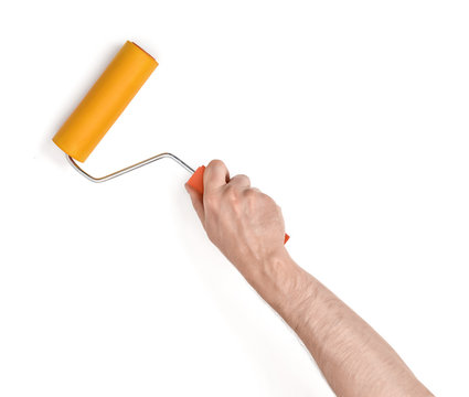 Close-up view of man's hand with paint roller, isolated on white background