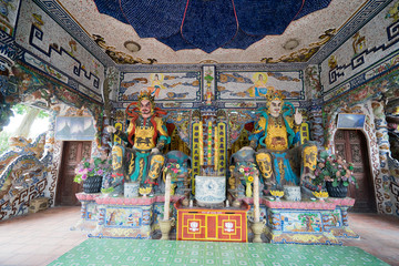 Multi-colored statues of gods inside the Buddhist temple in Vietnam