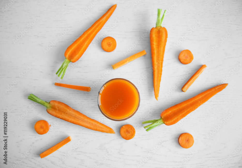 Wall mural Fresh carrot juice on wooden table