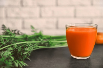 Fresh carrot juice in glass on table