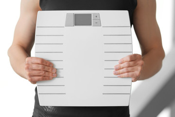 Man holding weight scale, close up