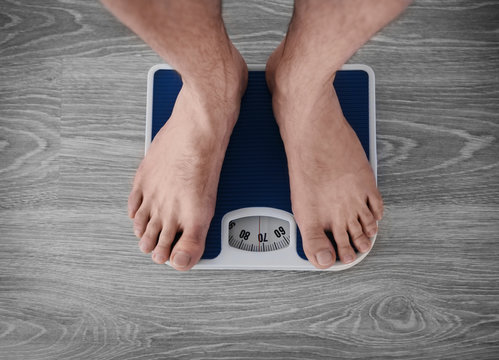 Man Standing On Weight Scale