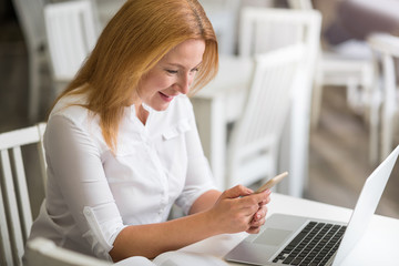 Delighted woman sitting at the table