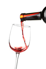 Red wine pouring into glass on white background