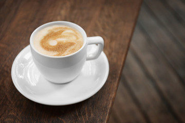 Cup of fresh coffee on wooden table