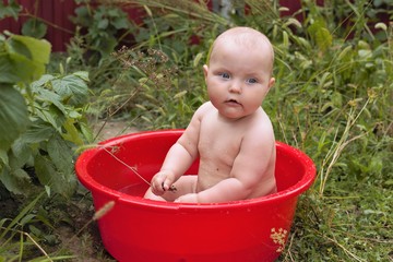 baby in red washbowl