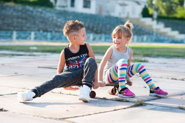 boy and a girl sitting on a skateboard