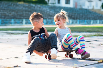 boy and a girl sitting on a skateboard
