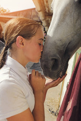 jeune fille embrassant cheval dans box 