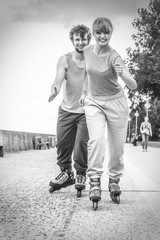 Two people race together riding rollerblades.