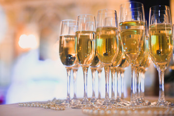 Beautiful row line of different colored alcohol cocktails on a party, martini, vodka,and others on decorated catering bouquet table on open air event, picture with beautiful bokeh
