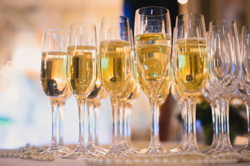 Beautiful row line of different colored alcohol cocktails on a party, martini, vodka,and others on decorated catering bouquet table on open air event, picture with beautiful bokeh
