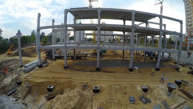 Construction site with workers and crane, time-lapse