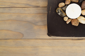 Tea light candle on metal with pebbles, right