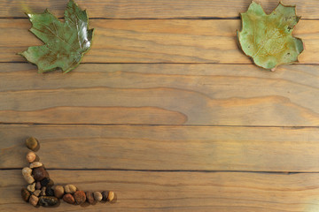 Two ceramic leaves with pebbles on wooden table