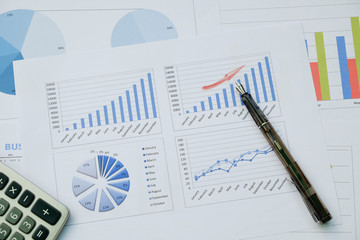 Obraz premium Desk office with pen, analysis report ,calculator. view from top. concept of business analysis, data analysis.