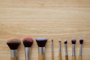 brush for make up on wood table, natural day light, selective focus, space for copy