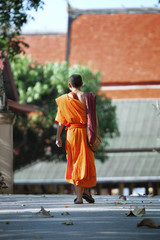 Photo of thai Buddhist monk is going toward to temple 