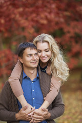 Fototapeta premium Happy smiling couple in a park in the autumn