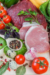 Raw meat and spices on rustic wooden board