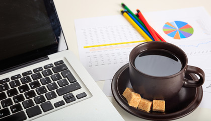 Office desk with laptop and a cup of coffee
