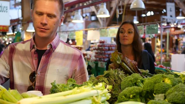 Couple buying fresh vegetables at market