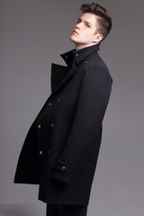 Obraz na płótnie Canvas Fashion shot of a young handsome man in black coat.