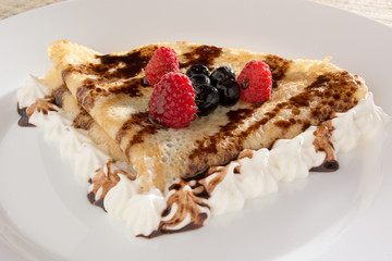 Fresh, golden pancakes with fruit and cream