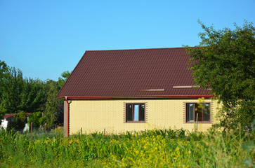 Fototapeta na wymiar Cozy brick house with metal roof exterior. Suburban house.