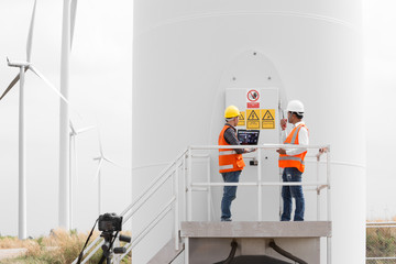 Engineers and technician working in wind turbine station