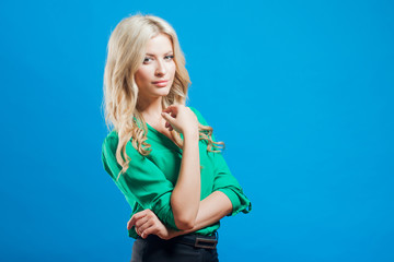 Portrait of young confident blonde, casual style, blue background