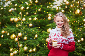 Young woman on a street of Paris decorated for Christmas